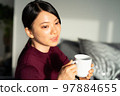 Woman relaxing in the living room 97884655