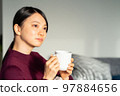 Woman relaxing in the living room 97884656