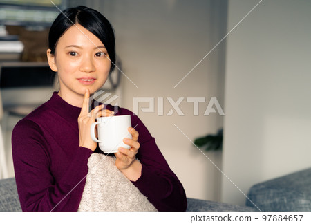 Woman relaxing in the living room Woman relaxing in the living room 97884657