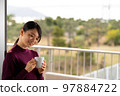 A woman relaxing on the terrace with a cup of coffee 97884722