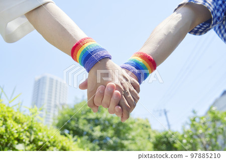 一對男性夫婦戴著彩虹色腕帶在戶外散步,不露面 一對男性夫婦戴著彩虹色腕帶在戶外散步,不露面 97885210