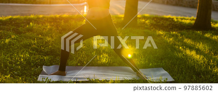 Banner pregnant woman belly in black tracksuit makes heroe pose standing barefoot on rug on green lawn on sunny summer day copy space. Childbirth preparation and nervous calming concept Banner pregnant woman belly in black tracksuit makes heroe pose standing barefoot on rug on green lawn on sunny summer day copy space. Childbirth preparation and nervous calming concept 97885602