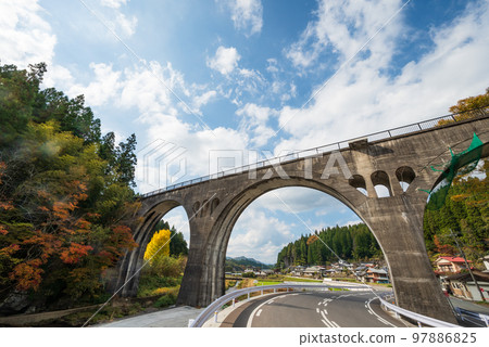 有秋葉的被放棄的鐵路混凝土拱橋 97886825