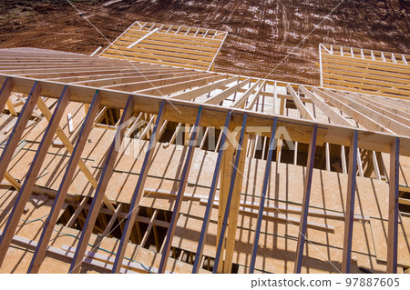 An wooden roof beam being constructed for newly constructed stick home from framework trusses 97887605