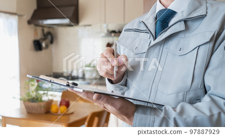 A man in work clothes inspecting the living room/kitchen | Renovation survey/estimate image 97887929