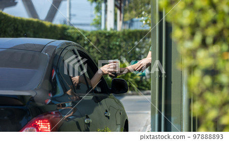 Hand Man in car receiving coffee in drive thru fast food restaurant. Hand Man in car receiving coffee in drive thru fast food restaurant. 97888893