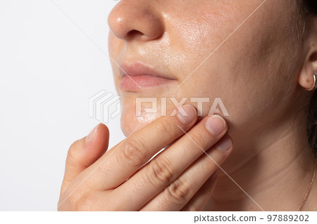 The woman puts oil on the skin and massages the face. Hydrophilic oil, improved blood circulation and prevention of wrinkles. 97889202