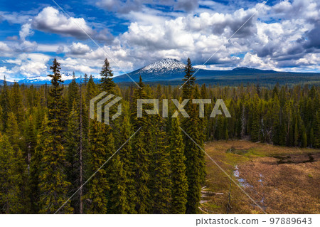 Aerial view of Mt. Bachelor over forests from Lava Lake Road in Oregon, USA Aerial view of Mt. Bachelor over forests from Lava Lake Road in Oregon, USA 97889643