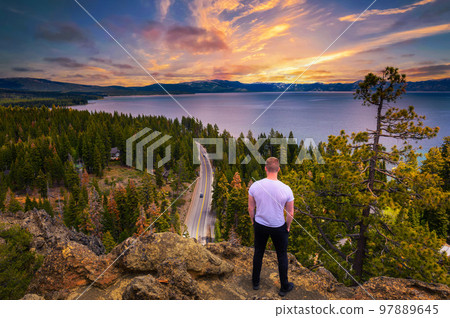 Hiker enjoying sunset over Lake Tahoe from the Eagle Rock in California Hiker enjoying sunset over Lake Tahoe from the Eagle Rock in California 97889645