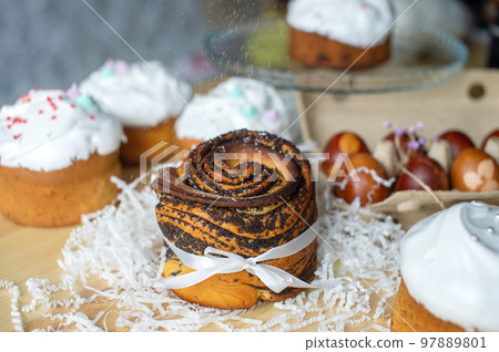 Festive poppy seed kraffin is on the table with Easter eggs and pastries Festive poppy seed kraffin is on the table with Easter eggs and pastries 97889801