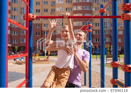 Cute baby and daddy play on the playground 97890116