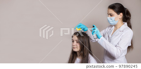 A dermatologist or trichologist applies a dandruff or lice weed to the patient's hair. Treating psoriasis, hair loss, dermatitis or head lice. A dermatologist or trichologist applies a dandruff or lice weed to the patient's hair. Treating psoriasis, hair loss, dermatitis or head lice. 97890245