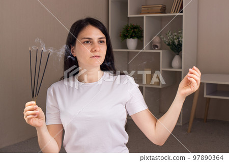 A woman holds a set of aromatic sticks in her hands. Aromatherapy, alternative medicine, treatment of neurosis and headache. 97890364