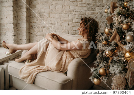 A young beautiful girl in a New Year's interior. A young beautiful girl in a New Year's interior. 97890404