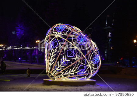 Sculptures with lighting in the form of Christmas tree toys in the park at night. Beautiful giant Christmas tree toys with lights in the city. Sculptures with illumination. Sculptures with lighting in the form of Christmas tree toys in the park at night. Beautiful giant Christmas tree toys with lights in the city. Sculptures with illumination. 97890680