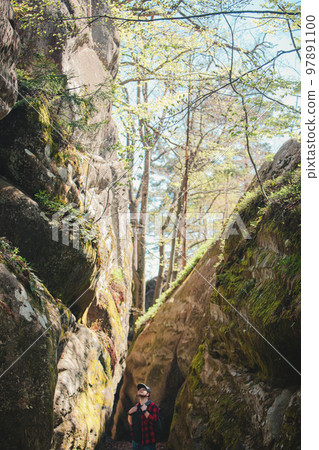 man hiker with backpack walking by trail in canyon 97891100