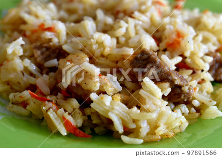 Boiled rice with meat on a plate. 97891566