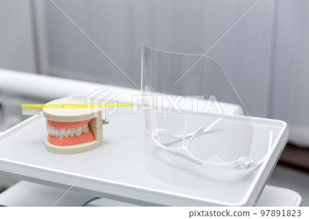 Clean teeth dental jaw model and yellow thooth brush on gray background. Clean teeth dental jaw model and yellow thooth brush on gray background. 97891823