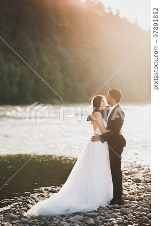 Romantic wedding moment, couple of newlyweds smiling portrait, bride and groom hugging 97891852