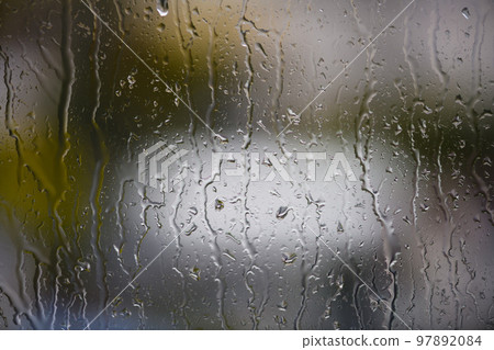View of blurred city through the home window with raindrops View of blurred city through the home window with raindrops 97892084