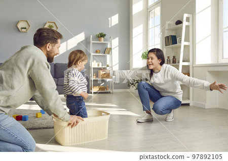 Happy young mother, father and little son playing and having fun together at home 97892105