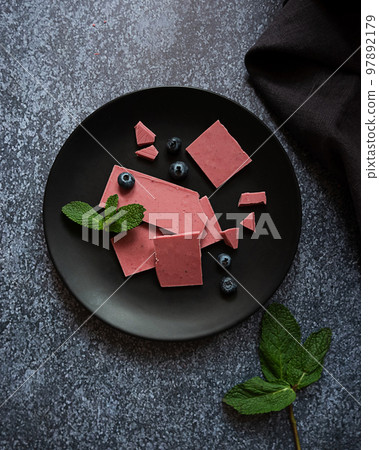 Pink or ruby chocolate, trendy dessert on a black plate on dark backround Pink or ruby chocolate, trendy dessert on a black plate on dark backround 97892179