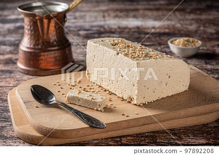 Tahini halva and a cezve on vintage wooden background Tahini halva and a cezve on vintage wooden background 97892208