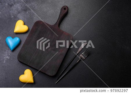 Chocolate hearts in the colors of the Ukrainian flag on a black ceramic plate 97892297