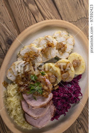 smoked meat served with red and white cabbage and two kinds of dumplings smoked meat served with red and white cabbage and two kinds of dumplings 97892423