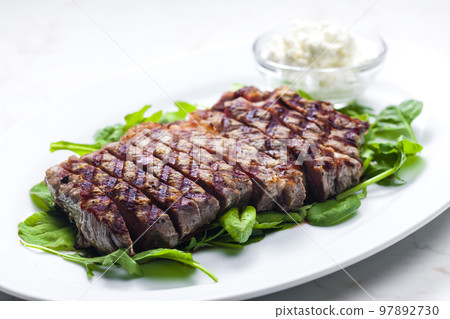 beef steak with garlic dip and spinach and ruccola leaves 97892730