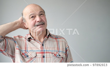 Senior hispanic man trying to remember something or having terrible headache. 97892813
