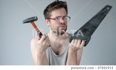 Young caucasian worker man holding a hammer isolated on grey background 97892914
