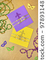 Multi color Mardi Gras background with beads and envelop. Top view 97893148