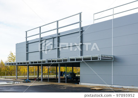 Unfinished metal frame warehouse building facade covered with thermally insulated sandwich panels 97893952