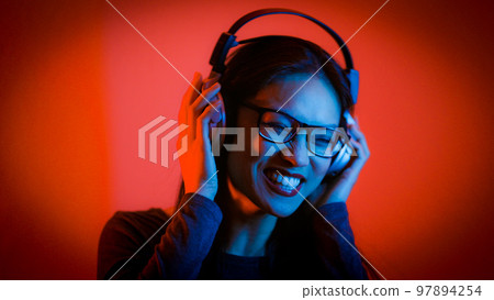 Young Asian woman listens to music - strong colorful shot 97894254