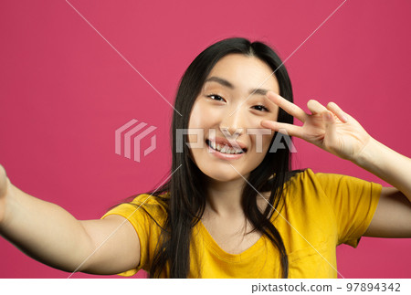 Portrait of joyful chinese lady taking selfie, point of view pov shot of female looking at camera and showing v-sign Portrait of joyful chinese lady taking selfie, point of view pov shot of female looking at camera and showing v-sign 97894342
