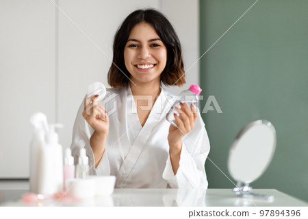 Lady using micellar water and cotton pad for makeup removal Lady using micellar water and cotton pad for makeup removal 97894396