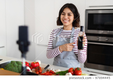 Pretty brunette woman recording food vlog, cooking at home 97894445