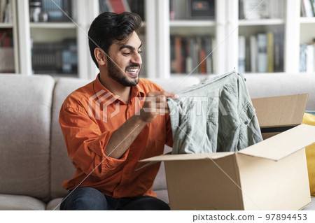 Excited middle eastern man customer receive good parcel, home interior Excited middle eastern man customer receive good parcel, home interior 97894453