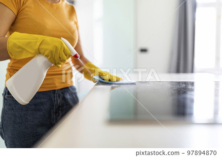 Young Woman Using Detergent Spray And Rag While Wiping Table In Kicthen 97894870