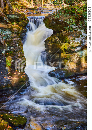 Detail of small waterfall through rocks covered in lichen and moss Detail of small waterfall through rocks covered in lichen and moss 97895014