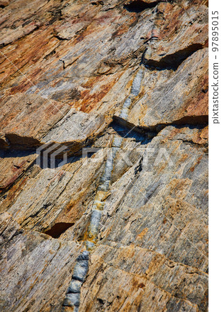Detail of tiny mineral quartz vein running through rocks in Maine Detail of tiny mineral quartz vein running through rocks in Maine 97895015
