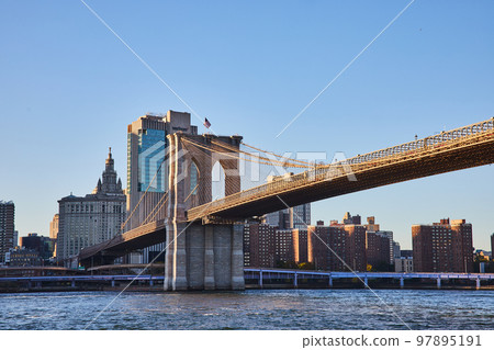 Brooklyn Bridge in New York City with city skyline in background along river Brooklyn Bridge in New York City with city skyline in background along river 97895191