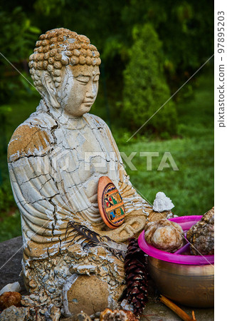 Buddha statue with cracks and donations for prayer and meditation 97895203