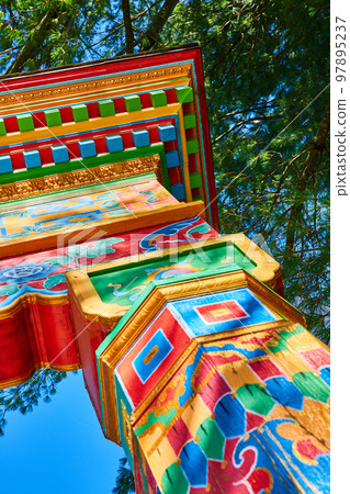 Colorful posts with Tibetan Mongolian Buddhist art at gate 97895237