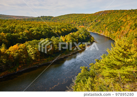 Delaware river in early fall with signs of yellow trees 97895280