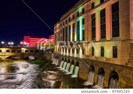 City lights at night in Rochester New York by river with manmade waterfalls 97895285