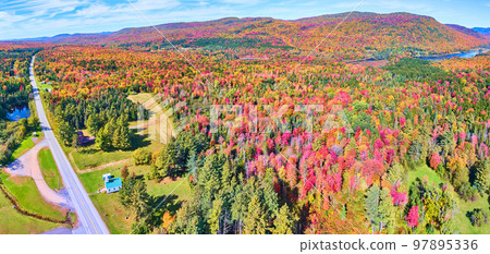 Aerial over road going through beautiful hills of peak fall foliage Aerial over road going through beautiful hills of peak fall foliage 97895336