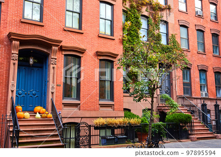 Beautiful street in New York City Greenwich Village with blue door and pumpkins 97895594