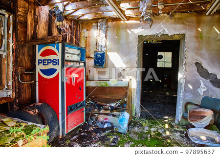 Abandoned Pepsi vending machine in front entrance of abandoned building 97895637